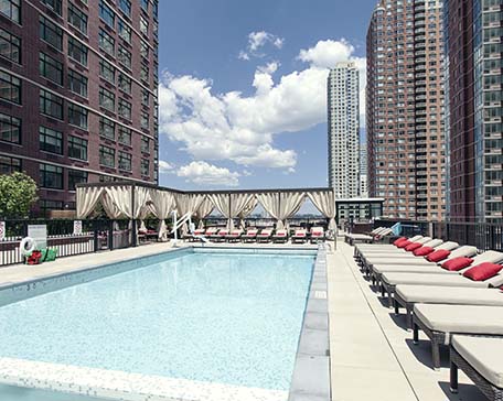 View of pool and cabanas at the 110 First Street Jersey City Apartments
